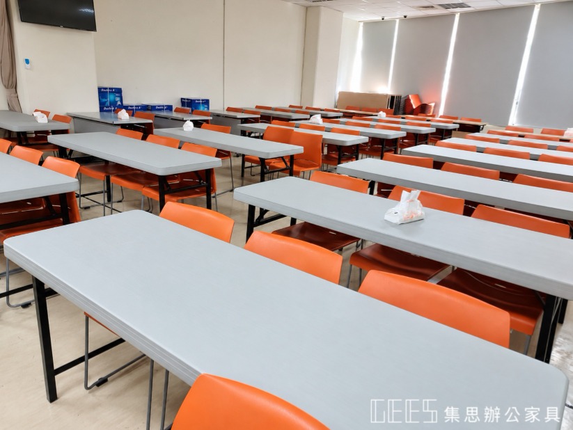 桃園區戶政事務所塑鋼折合桌併排配置：黑色座椅分列桌面兩側，前方可見投影布幕